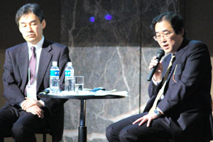 KDDI プラットフォーム開発本部 本部長 吉満 雅文氏(左)と三菱東京UFJ銀行 執行役員 システム部長 根本 武彦氏